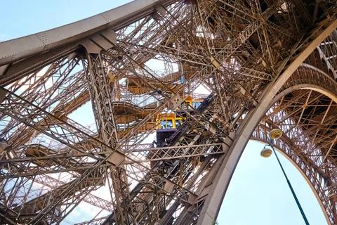 Yellow diagonal elevator inside the metal support of the Eiffel Tower 写真素材