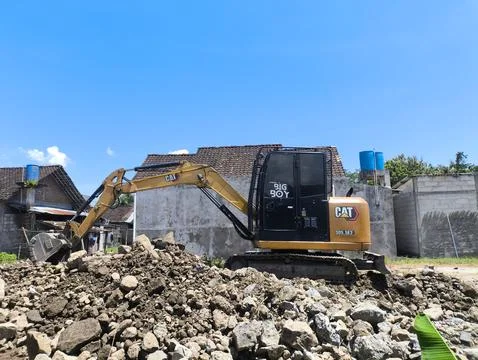 Yellow digger breaks down old structure Stock-Fotos