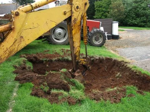 Yellow Digger digging out foundations for an extinction  Stock Photos