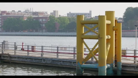 Yellow Docking Structure in Calm Water, Urban Riverbank Setting Stock Footage 330976557