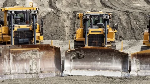 Yellow dozer parade of different sizes Stock Footage 289381971