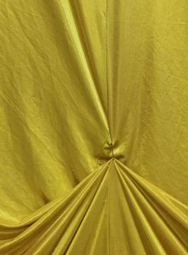 Yellow Draped Fabric Texture Background With Folded Textile Pattern 库存照片