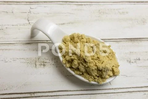 Yellow dry mustard in white china spoon. Stock Photos