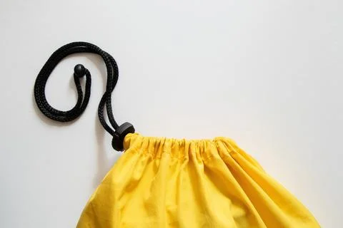 Yellow duffel bag with drawstring and clip on white background close-up Stock Photos