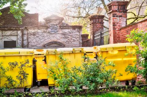 Yellow dumpster standing on an inner yard Stock Photos