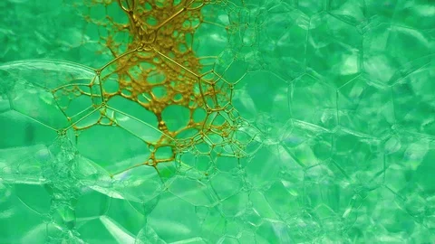 Yellow dye flowwing through green bubbly background Stock Footage 127924629