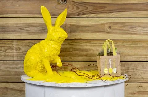 Yellow Easter bunny on white semicircular wooden table with bag Foto stock