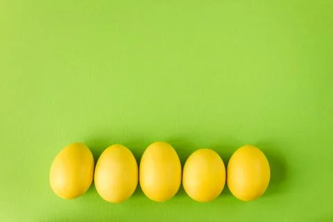 Yellow easter egg on bright green background Stock Photos