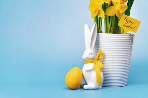 Yellow Easter egg bunny and blooming Daffodils in a pot Stock Photos