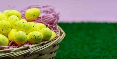 Yellow Easter Egg with freckles pattern inside a basket on top of grass Stock Photos