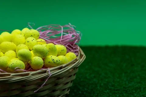 Yellow Easter Egg with freckles pattern inside a basket on top of grass Stock Photos