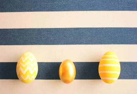 Yellow easter eggs on striped background with retro filter effect Stock Photos