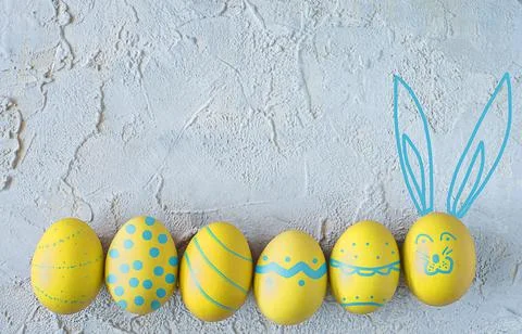 Yellow easter eggs on textured background. Top view. Copy space Stock Photos