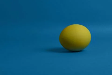 Yellow egg on blue background Foto stock