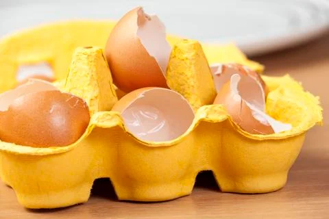 Yellow egg box full of broken egg shells Stock Photos