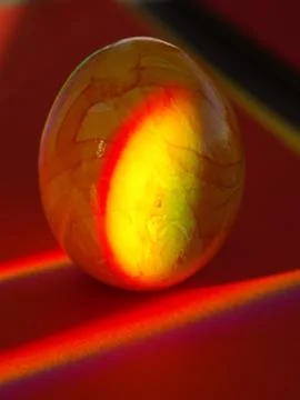 A yellow egg with a red background Stock Photos