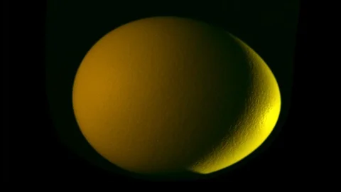 Yellow egg rotates on black background Stock Footage 104746404