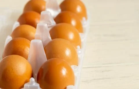 Yellow eggs in a pack of 10 on a light background Stock Photos