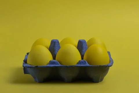 Yellow eggs on yellow background Stock Photos