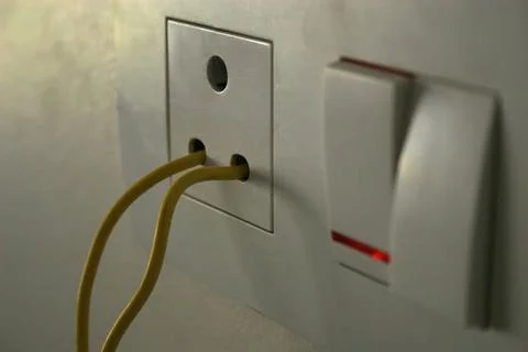 Yellow electric wire inserted in socket without plug and with switch on wh... Stock Photos