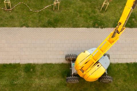 Yellow elevator working on a green grass. Stock Photos