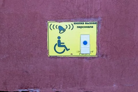 Yellow emergency call button for disabled people on a red textured wall Stock Photos
