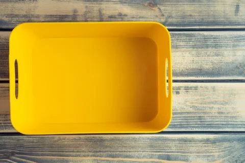 Yellow empty plastic container, box on wooden table background. Sustainable.. Stock Photos