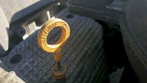 Yellow engine oil dipstick handle in car engine bay for maintenance Видео 331270551
