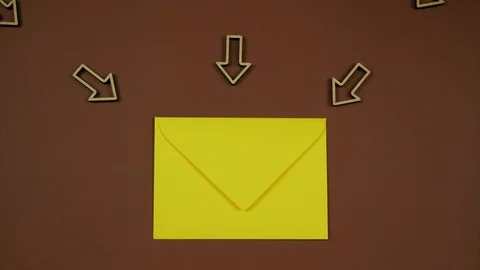 Yellow envelope with incoming arrows over brown background Stock Footage 102853316