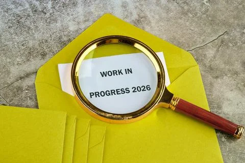 A yellow envelope sits on a textured surface, revealing a white document that Foto stock