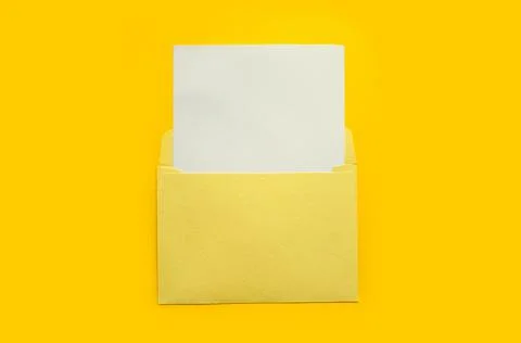 Yellow envelope with a white mockup sheet on yellow background Stock Photos