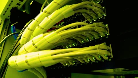 Yellow ethernet network cables plugged into a server rack switch Stock Footage 340355899