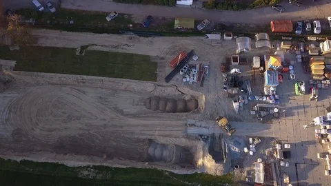 A yellow excavator at a construction site loads cement and crushed stone into Stock Footage 96035937