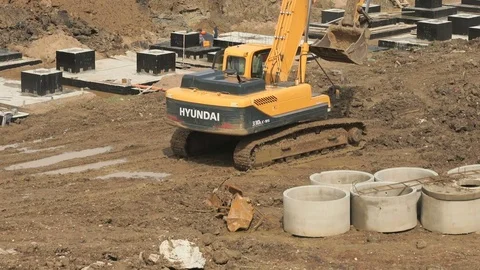 Yellow excavator on a construction site in summer Stock Footage