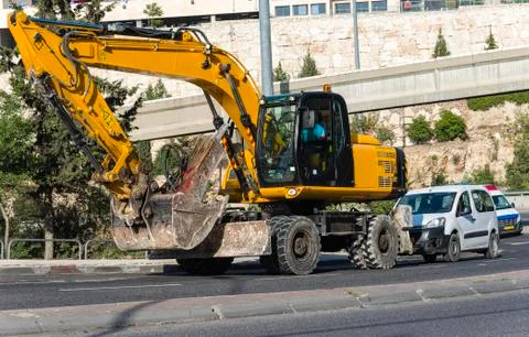 Yellow excavator machine with risen boom construction site Stock Photos