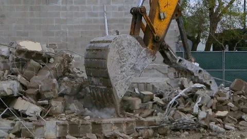 Yellow excavator picking up and dropping rubble into dump truck Stock Footage 115452957