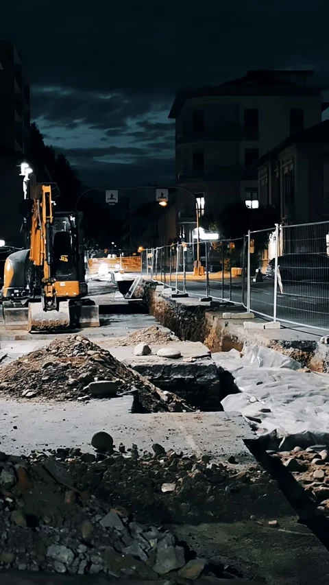 Yellow excavator standing at roadwork site during dark evening Stock Footage 334633579