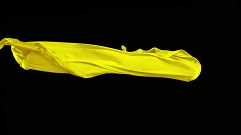 Yellow fabric flowing dynamically across dark backdrop in slow motion Stock Footage 327575761
