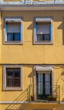 Yellow facade with large windows and balconies. Lisbon, Portugal Stock Photos