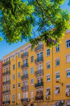 Yellow facade with large windows and balconies. Lisbon, Portugal Stock Photos