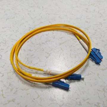 A yellow fiber optic patch core is located on the floor 스톡 사진