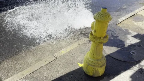 Yellow Fire Hydrant Spraying Water onto City Sidewalk Stock Footage 311559785