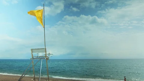 Yellow Flag at the beach in loop, 4k Stock Footage 115531123