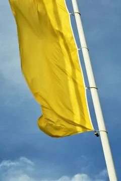 Yellow flag on a pole Stock Photos