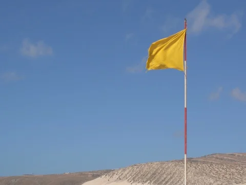 Yellow Flag waving on a beach Stock Footage