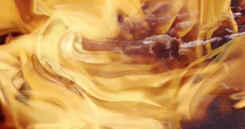 The yellow flames of the fire slowly lick the burning charred logs. Stock Footage 144985499