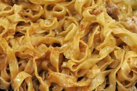 Yellow flat noodle called Mee Pok in close up macro photo for texture backgro Stock Photos