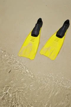 Yellow flippers on the beach Stock Photos