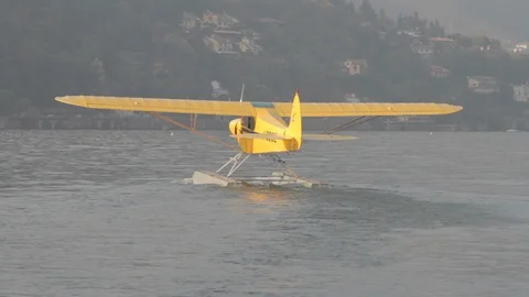 Yellow floatplane is floating on water in the Lake como Video stock 127823710