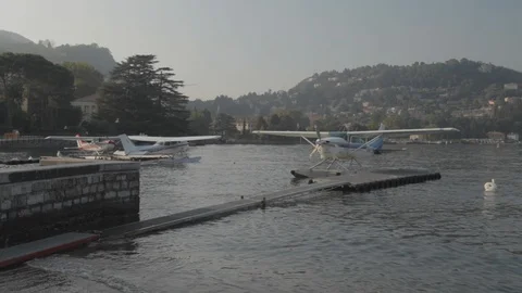 Yellow floatplane Lake como Mountains water Stock Footage 127823497